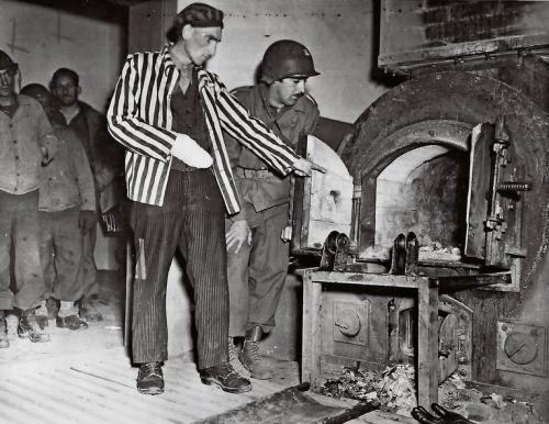 Ein polnischer KZ-Überlebender erklärt einem US -Soldaten den Krematoriumsofen im befreiten KZ Dora.